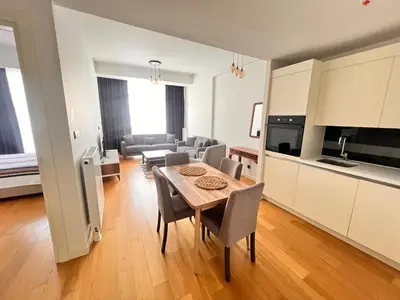a kitchen and living room with a table and chairs at Divan Residence - Güneşli Near Ataköy Metro Station in Istanbul