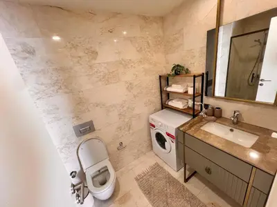 a bathroom with a toilet and a sink and a washing machine at Divan Residence - Güneşli Near Ataköy Metro Station in Istanbul