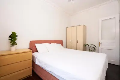a bedroom with a white bed and a wooden dresser at Cozy Apartment Next to Taksim Square in Istanbul