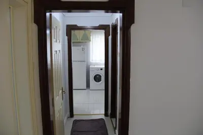 a hallway of a bathroom with a washer and dryer at Abbasi Apart (H) in Çekirge