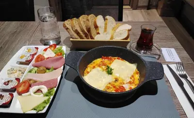 a table with a pan of food and a plate of bread at Castle Franco Suites in Istanbul