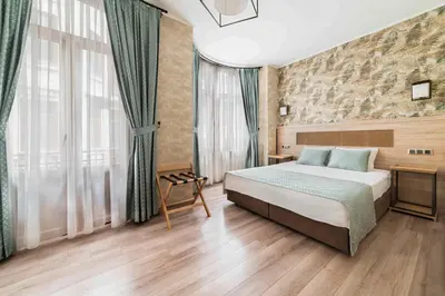 a bedroom with a bed and a large window at Castle Franco Suites in Istanbul