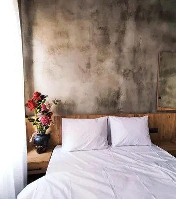 a bed with white sheets and a vase of flowers at Life Span Hotels in Istanbul