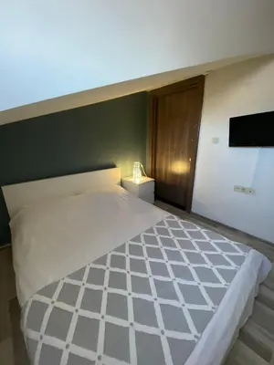 a bedroom with a large white bed with a flat screen tv at Istanbul Hub Flats in Istanbul
