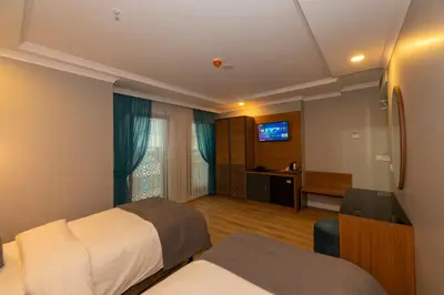 a hotel room with two beds and a television at New Emin Hotel in Istanbul