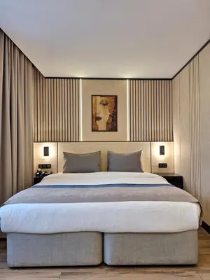 a bedroom with a large bed with two lamps at N'Ala Otel in Sakarya