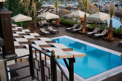 a pool with tables and chairs next to a building at Phellos Suites Boutique Hotel in Sile