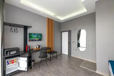a living room with a television and a table at Melanj Airport Hotel in Arnavutköy
