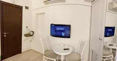 a room with a table and a tv on a wall at Nacre Residence in Istanbul
