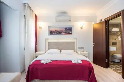 a bedroom with a large bed with a red blanket at Nacre Residence in Istanbul