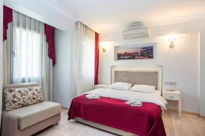 a bedroom with a large bed and a chair at Nacre Residence in Istanbul