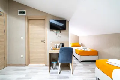 a room with two beds and a desk with a chair at Mardy Suit Hotel in Istanbul