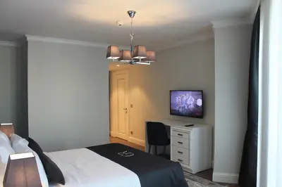 a bedroom with a bed and a desk with a television at Garlon Residence in Istanbul