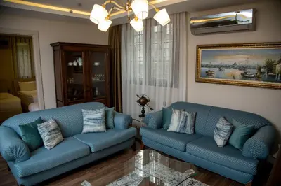 a living room with two blue couches and a painting at The Charm Hotel - Old City in Istanbul