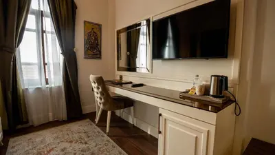 a room with a desk with a television and a chair at BANDIRMA PALAS OTEL in Bandırma