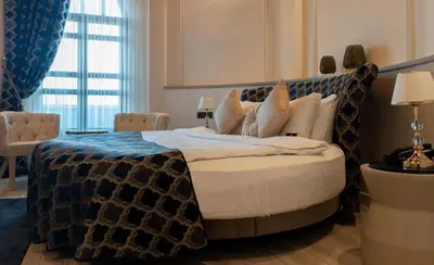 a bedroom with a bed with a blue and white blanket at BANDIRMA PALAS OTEL in Bandırma