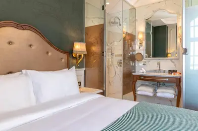 a bedroom with a bed and a bathroom with a shower at Orientbank Hotel Istanbul, Autograph Collection in Istanbul