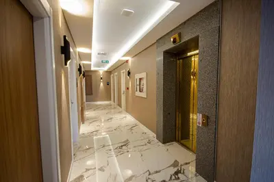 a hallway with white marble floors and a door at KAR BEYAZ HOTEL BURSA in Bursa