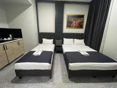 two beds in a small room with a tv at Taksim Galatist Hotel in Istanbul