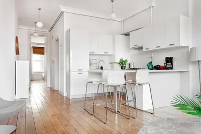 a white kitchen with white cabinets and bar stools at NOA - Tatar Beyi 18 in Istanbul