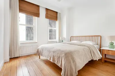 a white bedroom with a bed and two windows at NOA - Tatar Beyi 18 in Istanbul