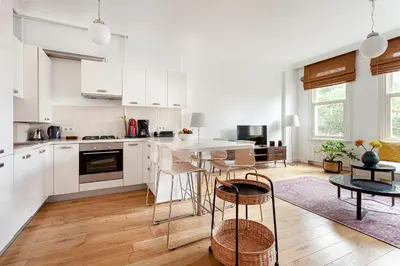 a kitchen with white cabinets and a table and chairs at NOA - Tatar Beyi 18 in Istanbul