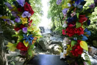a path with flowers in front of a waterfall at Naturkoy Sapanca in Sakarya