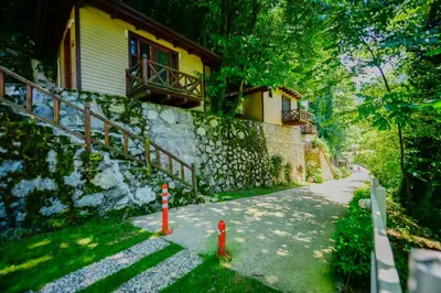 a house with a stone wall and a sidewalk next to a building at Naturkoy Sapanca in Sakarya