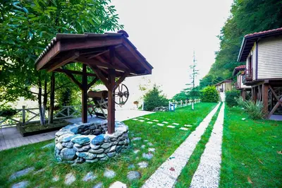 a small pavilion in the grass next to a house at Naturkoy Sapanca in Sakarya
