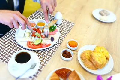 a table with plates of breakfast food and a cup of coffee at Burçman Hotel Vişne in Yıldırım