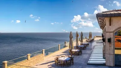 a row of tables and chairs on a balcony with the ocean at Birun Ada Hotel in Istanbul
