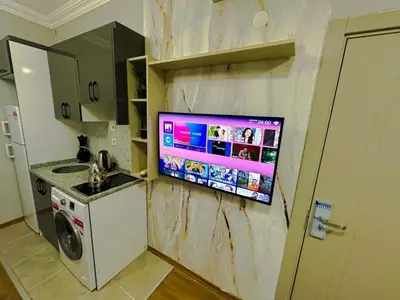 a tv hanging on a wall in a kitchen at Sisli House By Remar Holding in Istanbul