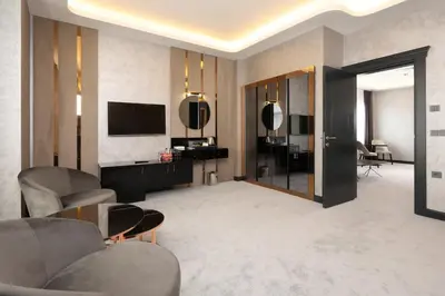 a living room with chairs and a television and a room at Aileena Hotel & Villas in Kartepe