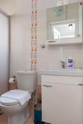 a white bathroom with a toilet and a sink at Dualis Hotel in Istanbul