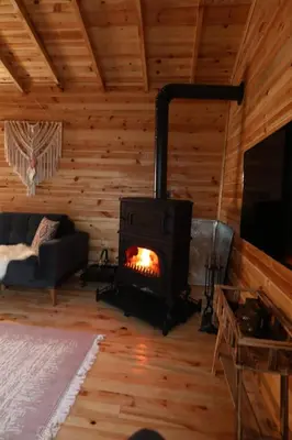 a living room with a fireplace in a log cabin at Dorabungalov in Sakarya