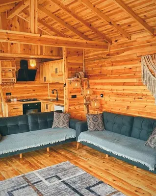 a living room with leather couches in a log cabin at Dorabungalov in Sakarya