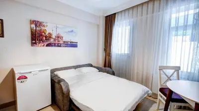 a bedroom with a bed and a table and a window at SEVEN ROSES APART HOTEL in Istanbul
