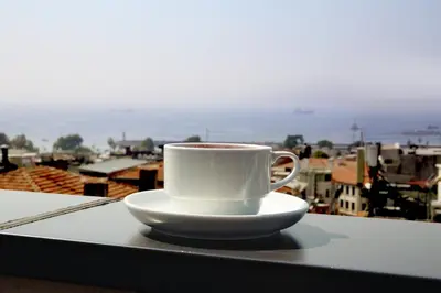 a cup of coffee sitting on a table with a view at The Grand Tower Hotel in Istanbul