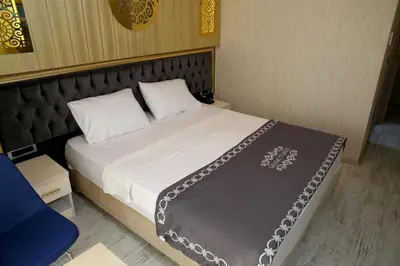a bedroom with a bed with white sheets and pillows at The Grand Tower Hotel in Istanbul