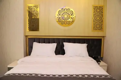 a bed with white sheets and a black headboard at The Grand Tower Hotel in Istanbul