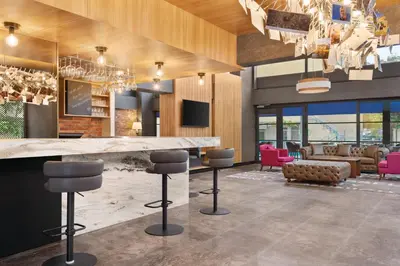 a lobby with a bar and pink chairs at Tryp by Wyndham Istanbul Atasehir in Istanbul