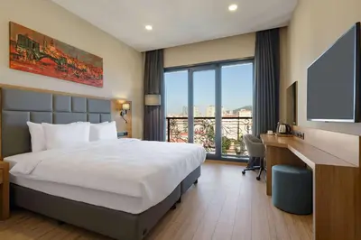 a hotel room with a bed and a desk and a television at Tryp by Wyndham Istanbul Atasehir in Istanbul