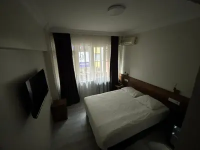a small bedroom with a bed and a window at Altinnal Hotel in Kocaeli
