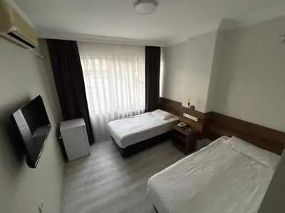 a hotel room with two beds and a window at Altinnal Hotel in Kocaeli