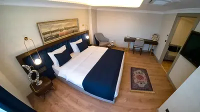 a bedroom with a large bed and a desk at Nevi Hotel & Suites Istanbul Taksim in Istanbul