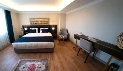 a bedroom with a large bed and a desk and a desk at Nevi Hotel & Suites Istanbul Taksim in Istanbul