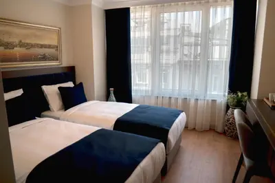 a hotel room with two beds and a window at Nevi Hotel & Suites Istanbul Taksim in Istanbul