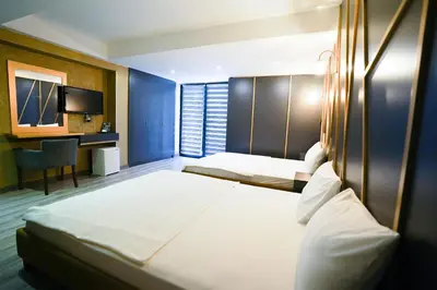 a hotel room with two beds and a desk at Time Hotel Mecidiyekoy in Istanbul