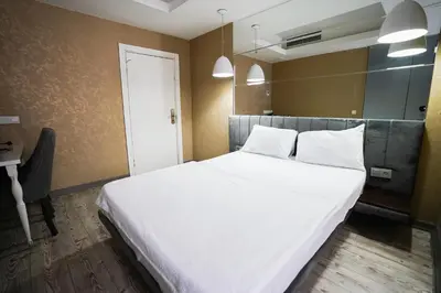 a bedroom with a large white bed and a desk at Time Hotel Mecidiyekoy in Istanbul