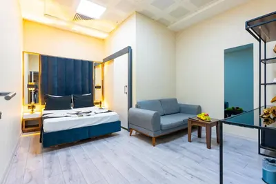 a bedroom with a bed and a chair and a table at MELİSA SUİT RESİDENCE in Istanbul